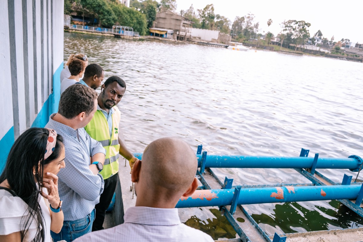 Nuru team showing visitors a water-pumping installation on Lake Kivu